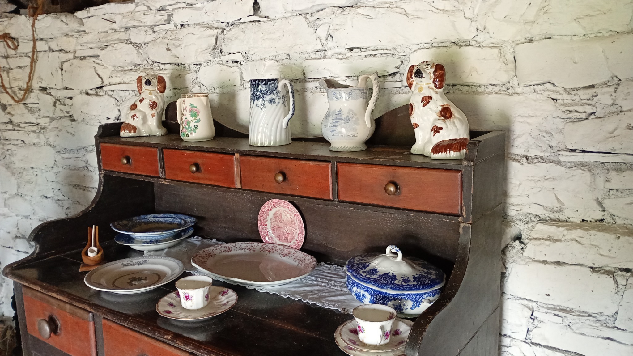 Period crockery arranged on a wooden dresser